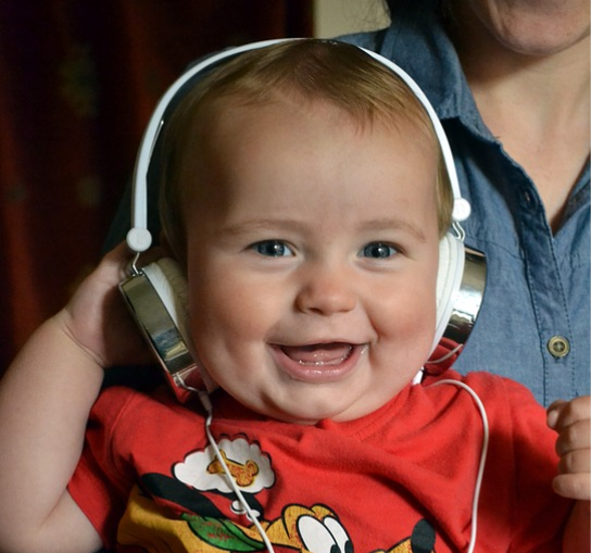Adorable baby with head phones. 