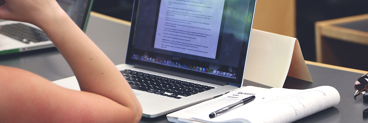 Teen doing homework with open laptop