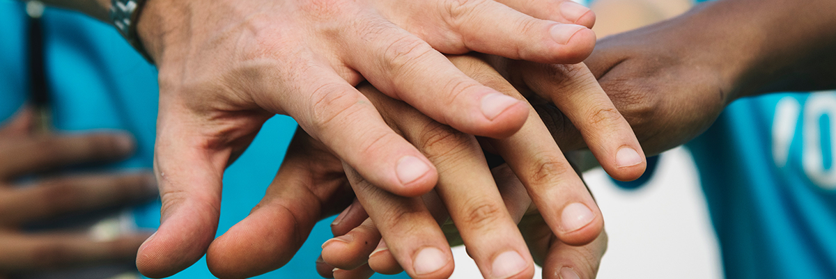 Volunteers putting theirs hands one on top of the other