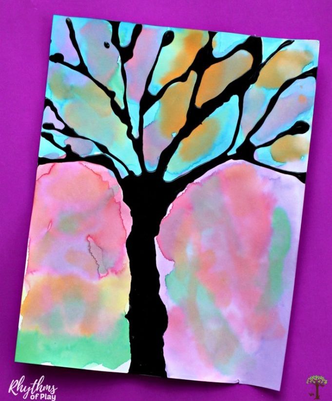 silhouette picture of a tree with no leaves on a pastel background