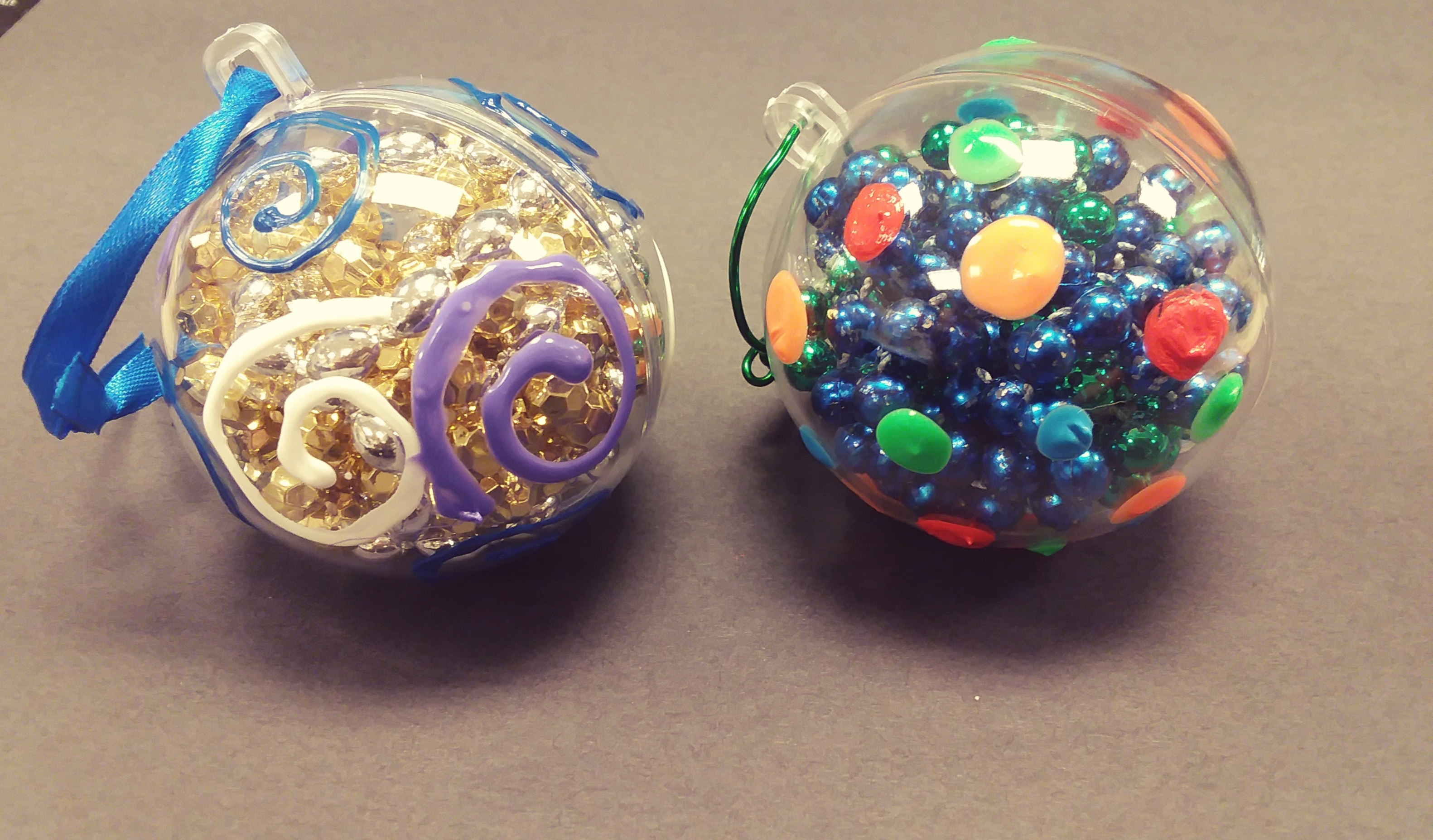 clear plastic ornaments painted with puffy paint and filled with shiny beads