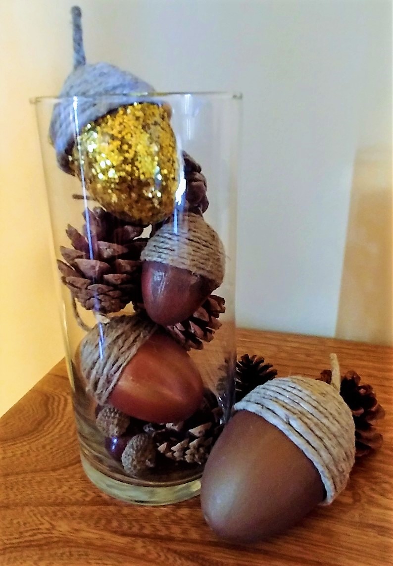 plastic easter eggs decorated to look like acorns in a glass vase