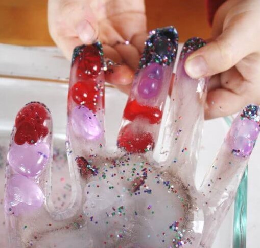 hand shaped ice with colorful items in the ice