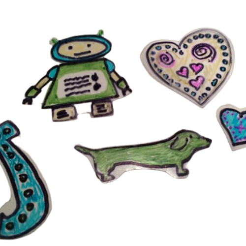 Examples of shrinky dink art "Letter J, heart, green dog, and robot"