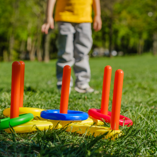 Child playing a ring toss game on the lawn