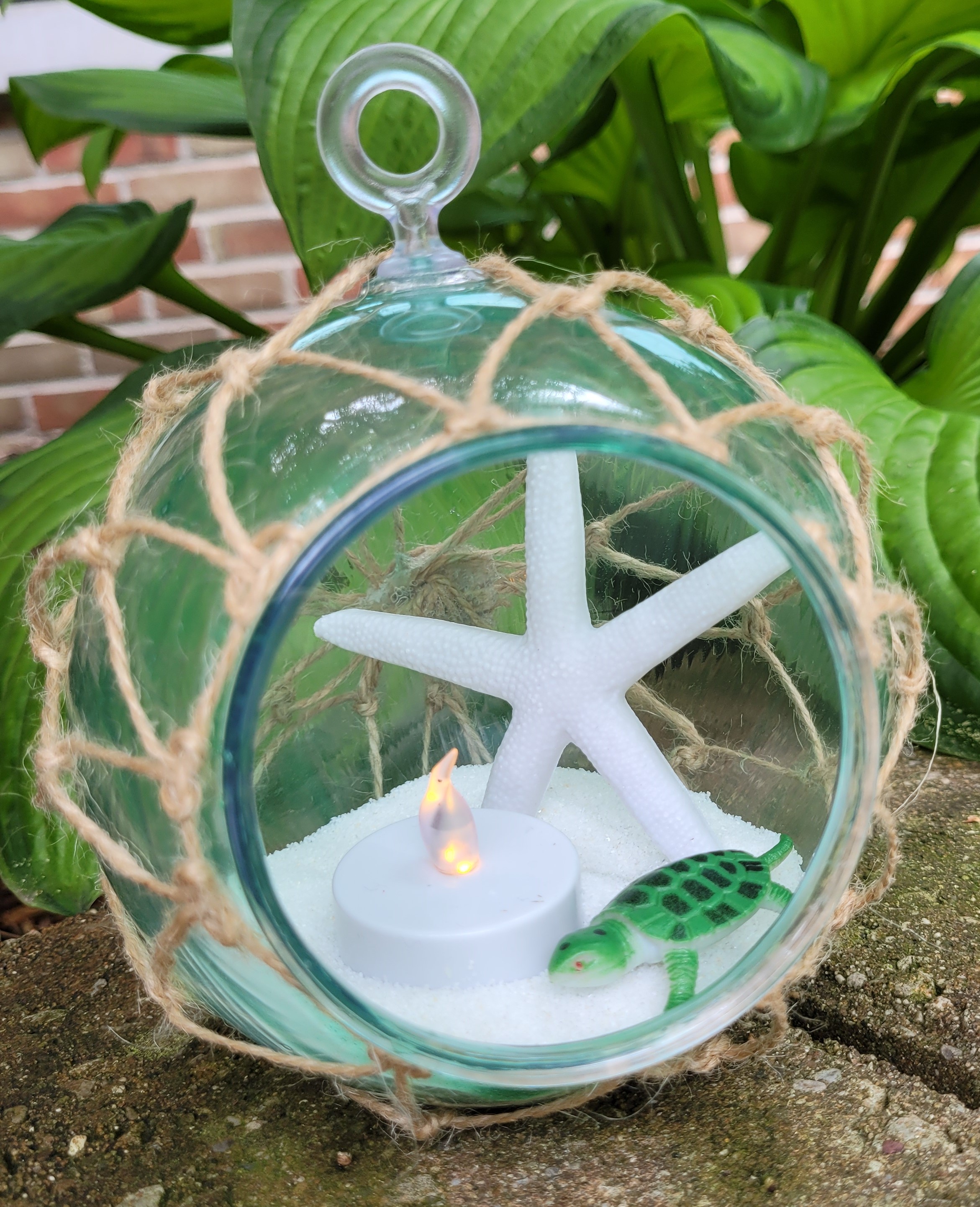 netted nautical style hanging luminary with sand, candle, starfish, turtle