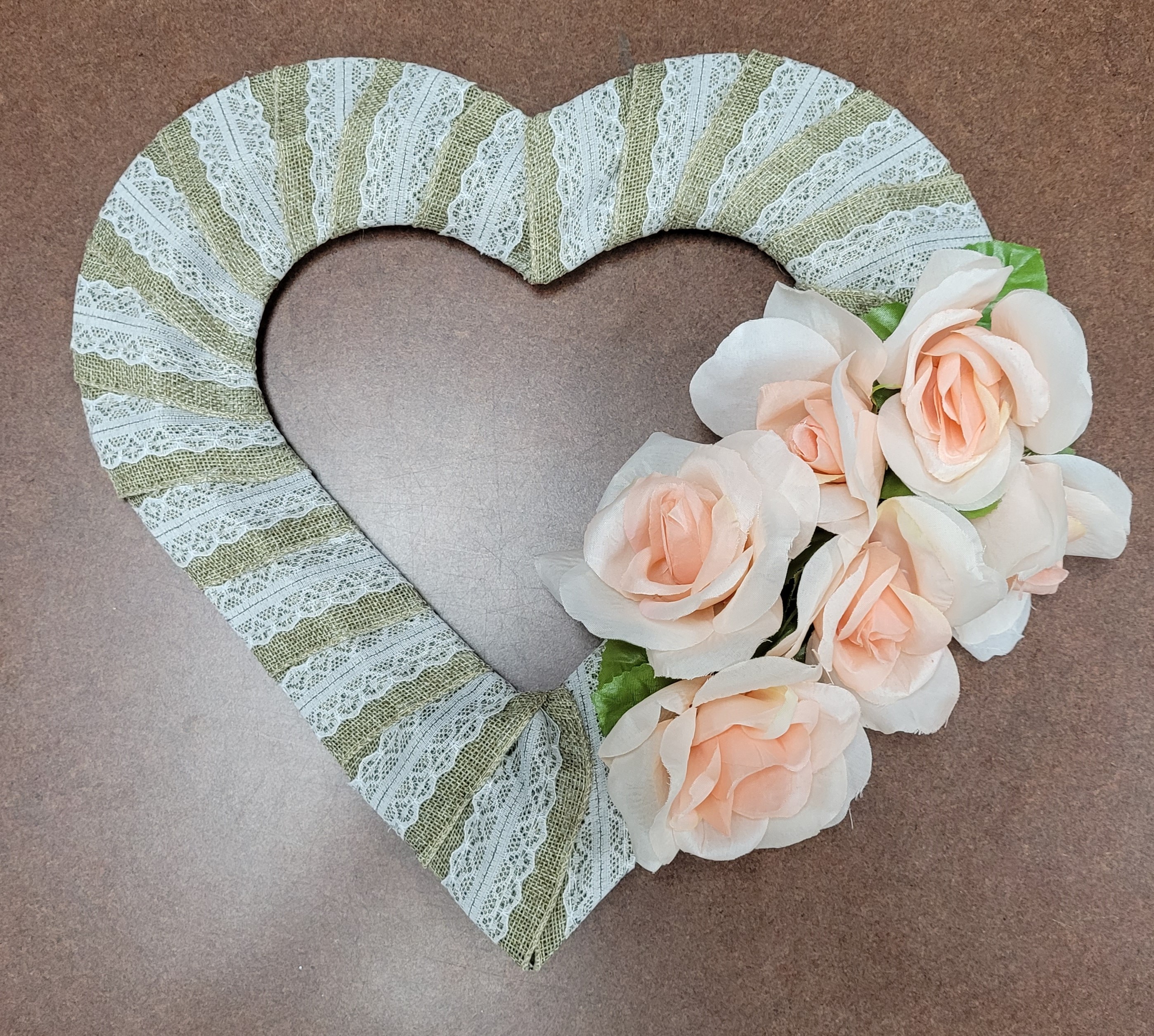 heart shaped wreath wrapped with lace burlap and adorned with flowers
