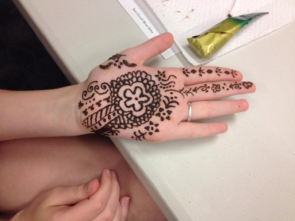 Image of hand palm up with henna design