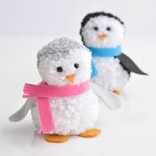 two penguins made of pom poms each wearing a scarf one blue one pink