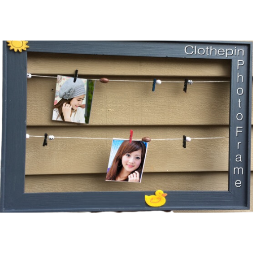 A photo frame with rope across the frame and clothes pins to hang pictures