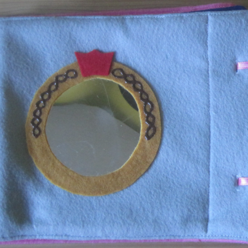 Light blue felt background with a circle mirror busy book example