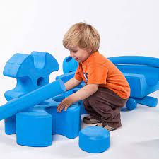 young boy playing with blue blocks building toy