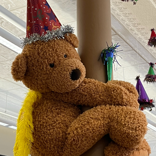 Bear with a party hat and birthday decorations