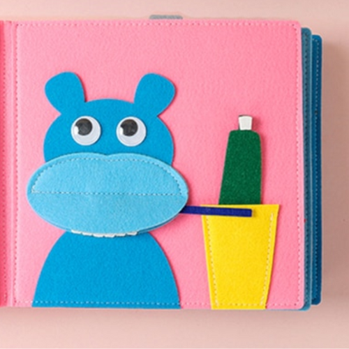 Pink background, blue hippopotamus focusing on brushing teeth (made out of felt pieces)