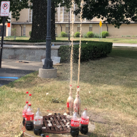 2 Liter soda bottles erupting in a geyser using Mentos