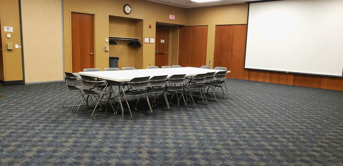 Wirt community room interior shot with conference table, chairs, and screen at front of room