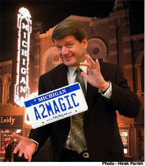 Man holding license plate that says "A2MAGIC"