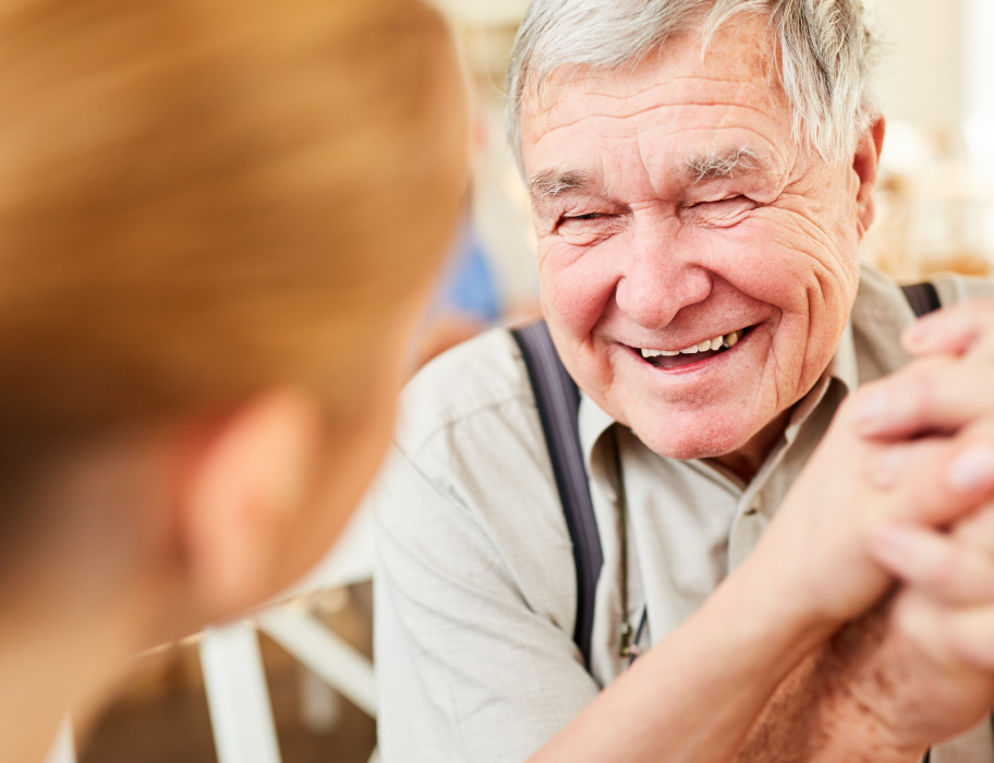 Elderly person interacting happily with caregiver